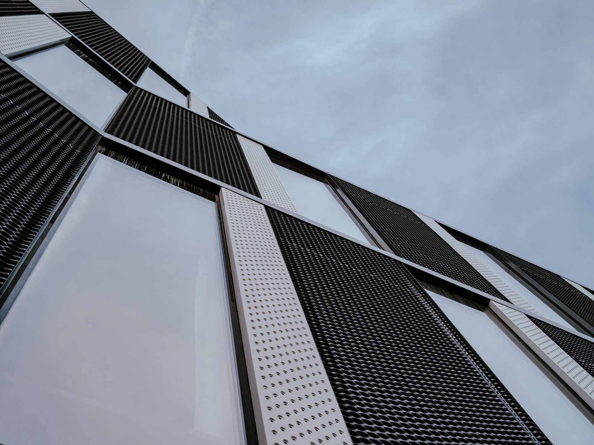 Low angle view of a modern building facade with futuristic architecture and sleek design.
